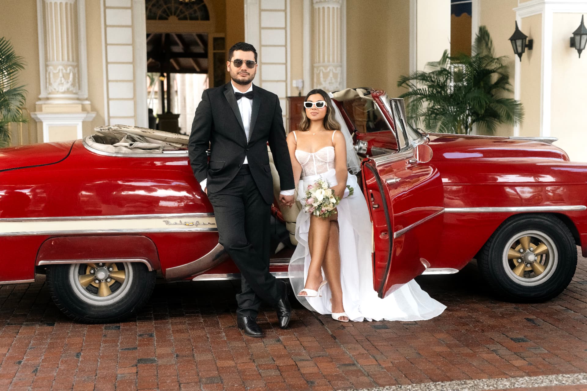 Angie Paulet y Juan Diego junto al auto clásico rojo